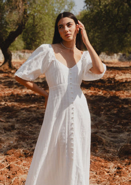 model wears a white midi dress