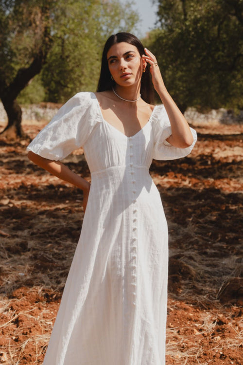 model wears a white midi dress