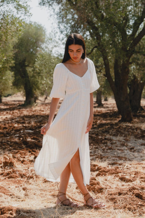 model wears a white midi dress