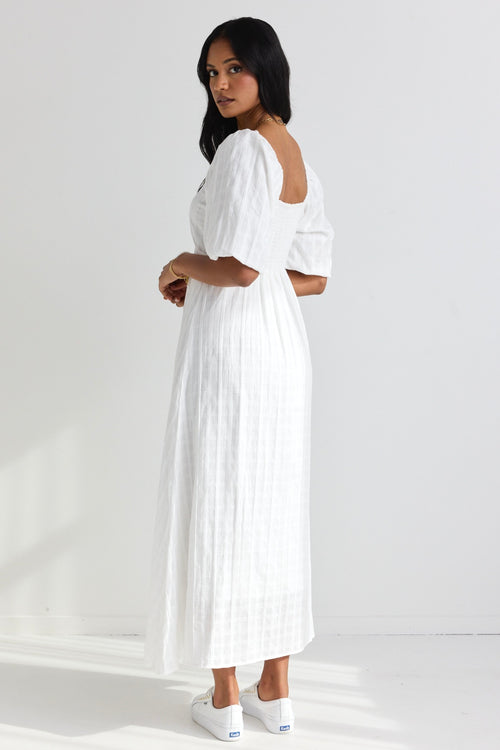 model wears a white midi dress