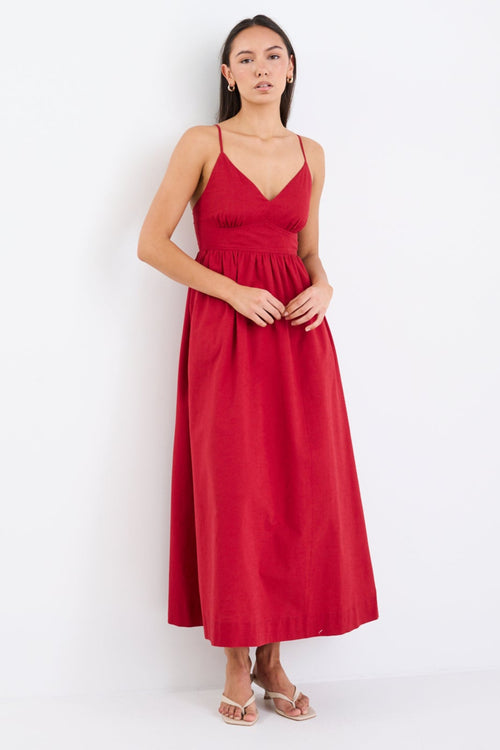 Model wearing a plum strappy midi dress, featuring a relaxed fit and linen-cotton blend fabric with a smooth, polished finish.