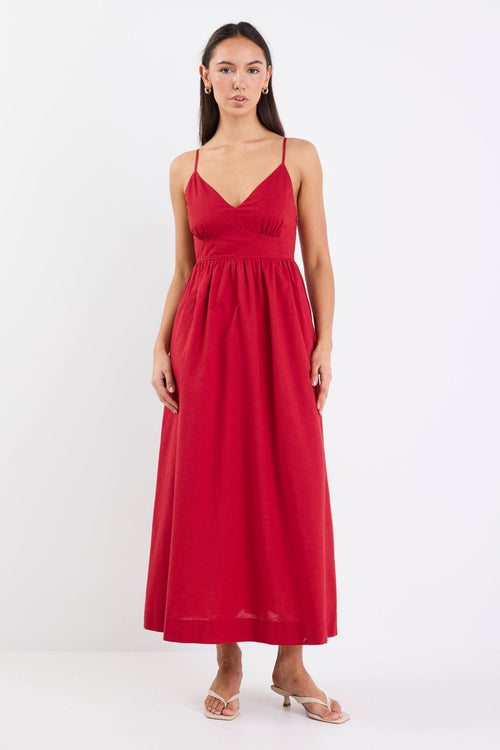 Model wearing a plum strappy midi dress, featuring a relaxed fit and linen-cotton blend fabric with a smooth, polished finish.