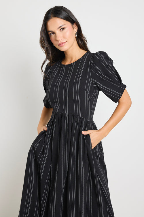 Model wears a black stripe maxi dress with short sleeves