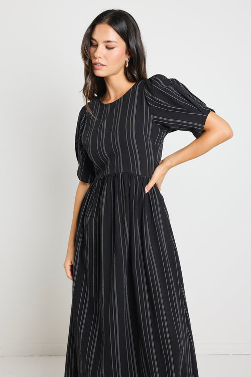 Model wears a black stripe maxi dress with short sleeves