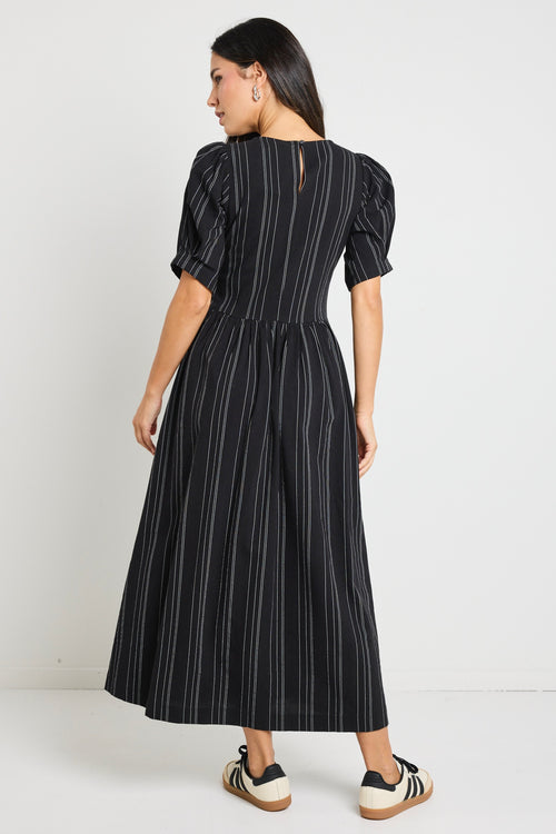 Model wears a black stripe maxi dress with short sleeves