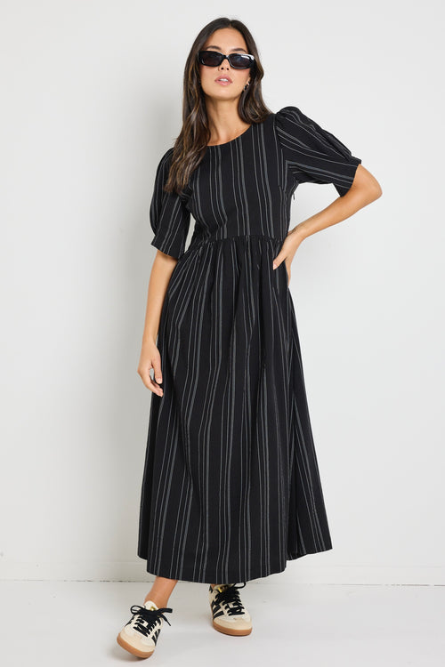 Model wears a black stripe maxi dress with short sleeves