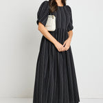 Model wears a black stripe maxi dress with short sleeves