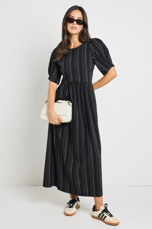 Model wears a black stripe maxi dress with short sleeves