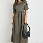 Model wears a khaki midi dress with rounded neckline