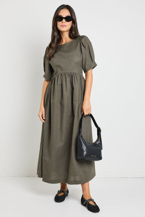 Model wears a khaki midi dress with rounded neckline