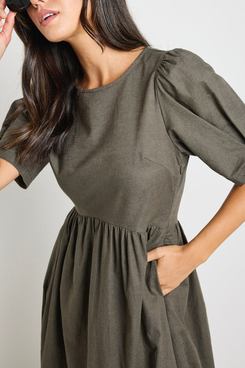 Model wears a khaki midi dress with rounded neckline