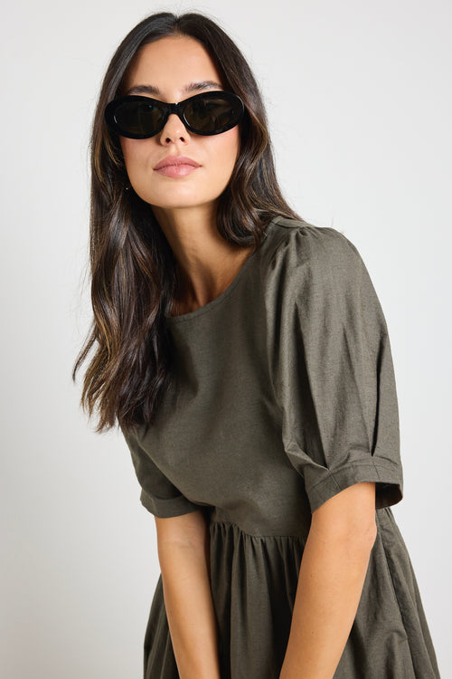 Model wears a khaki midi dress with rounded neckline