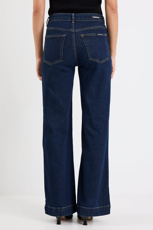 Person wearing dark blue jeans on a white background