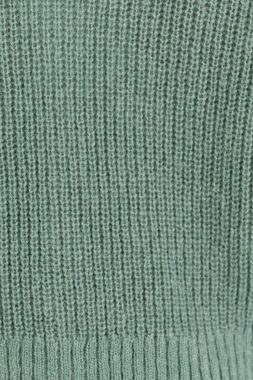 Close-up of a textured green fabric with a ribbed pattern