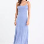 Model wearing a mini gingham strappy slip dress in electric blue, with adjustable straps and a flattering bias cut.