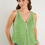 the model wears a green v-neck tank top with dark blue jeans