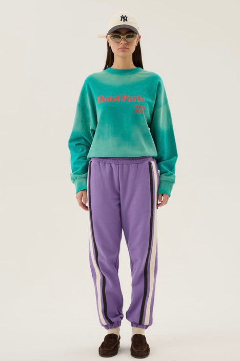 Woman wearing an oversized ocean green crew sweatshirt with 