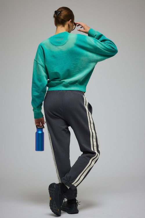 Woman wearing an oversized ocean green crew sweatshirt with 