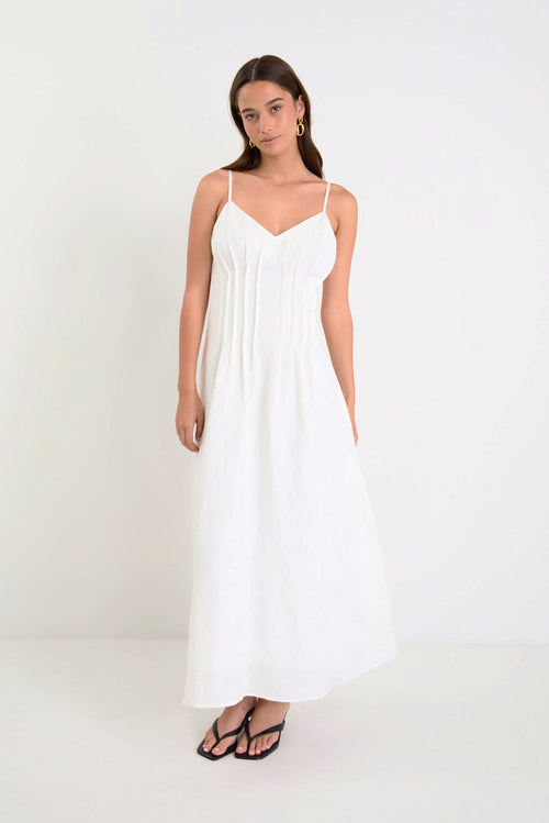 Woman wearing a white dress against a white background