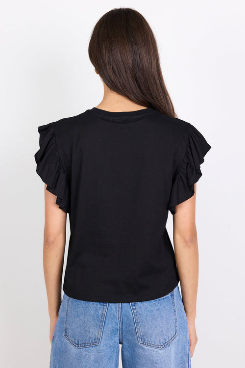 Person wearing a black top with ruffled sleeves and blue jeans on a white background