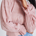 model wears a pink blouse