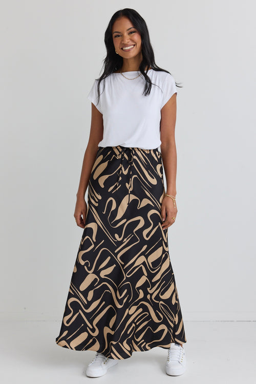 model wears a black and beige pattern maxi skirt