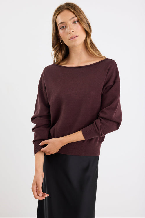 Woman wearing a dark brown sweater on a white background