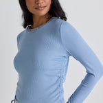 model wears a blue long sleeve top