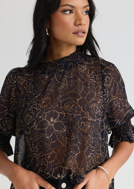 model wears a black floral blouse