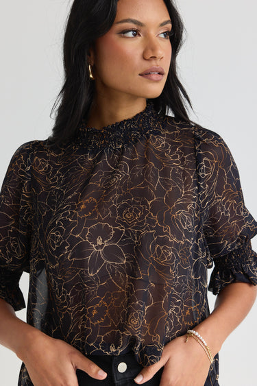 model wears a black floral blouse