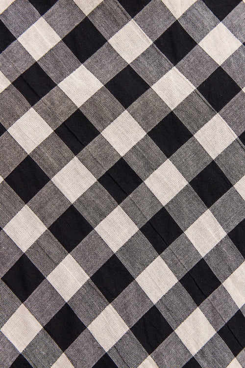 A close-up of a black and off-white gingham fabric pattern, showing the woven texture and diagonal checkered design.