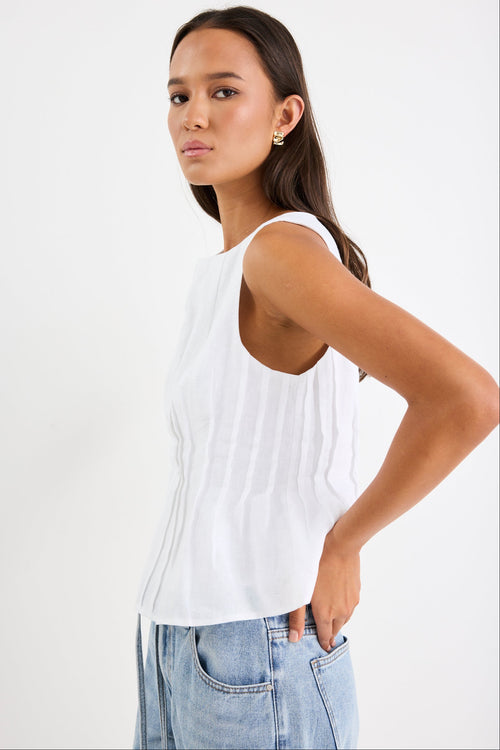 Woman wearing a white pintuck detail top