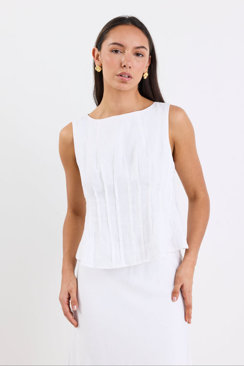 model wearing white top and white skirt