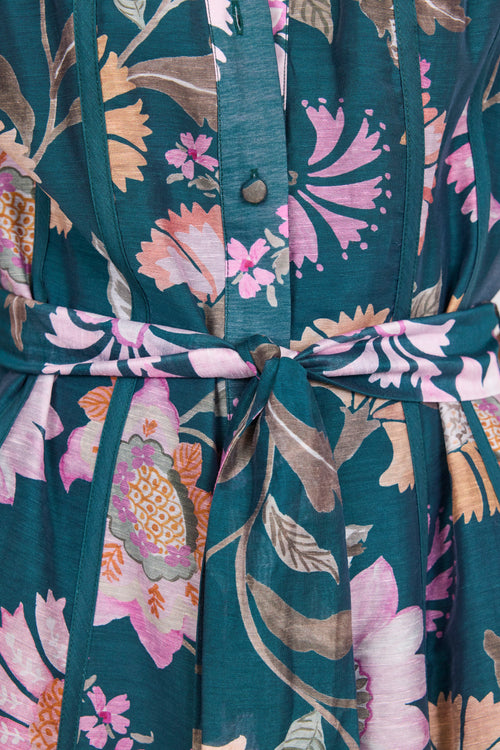 Floral patterned dress with a belt on a dark teal background