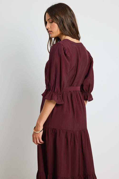 model wears a plum tie tiered dress