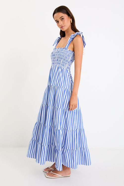 Woman wears a blue white striped maxi dress