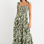 Model wearing a bold khaki zebra print dress with strappy tie details, a shirred bodice, and a tiered design. 