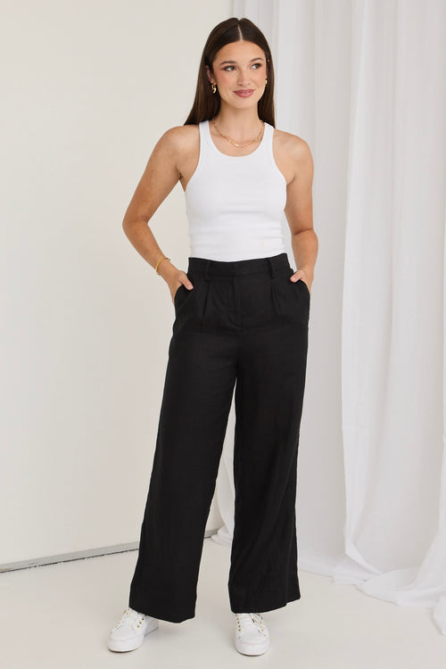 model wears black pants with white tee