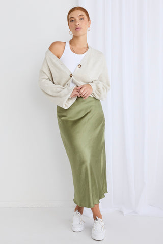 model wears a green satin mini skirt