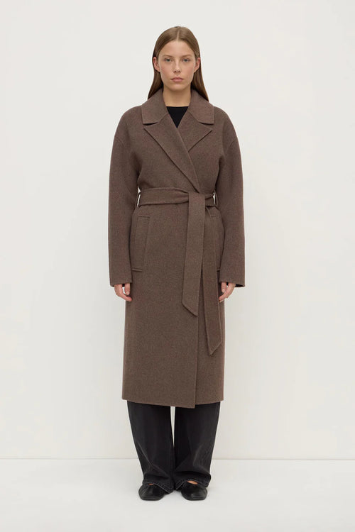 Woman wearing a brown coat on a white background