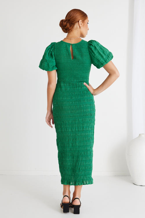 model wears a green midi dress