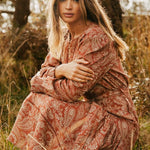 model wears a brown print dress