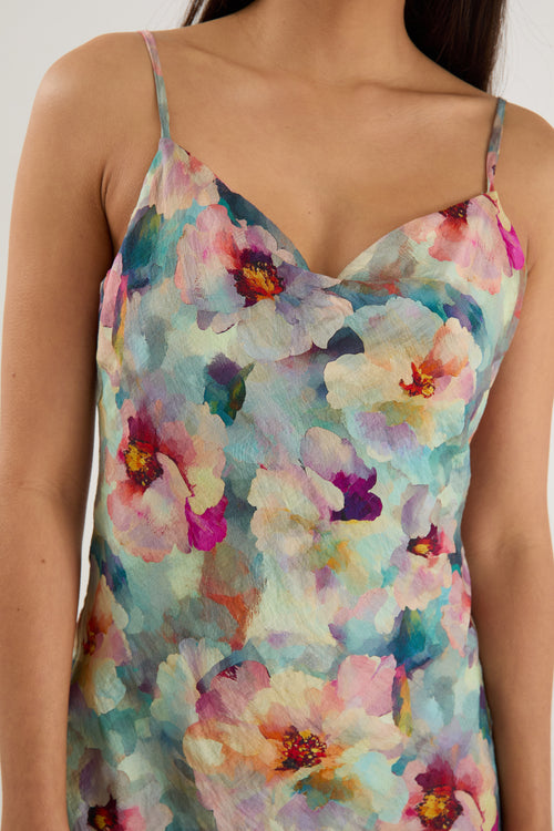 model wears a blue floral maxi dress with white heels