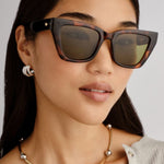 Dark tortoiseshell cat-eye sunglasses with angular frames and moss green lenses