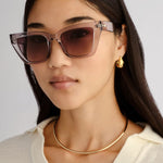 Transparent square cat-eye sunglasses with smoke gradient lenses.