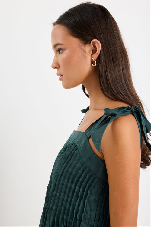 Woman wearing a green cami top and blue jeans