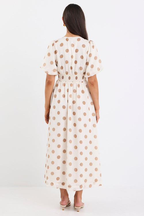 Woman wearing a cream brown polka dot maxi dress