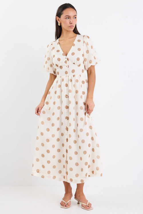 Woman wearing a cream brown polka dot maxi dress