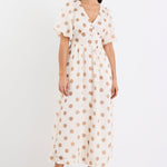 Woman wearing a cream brown polka dot maxi dress