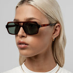 Honey tortoise aviator-style sunglasses with angular frames and green-tinted lenses.